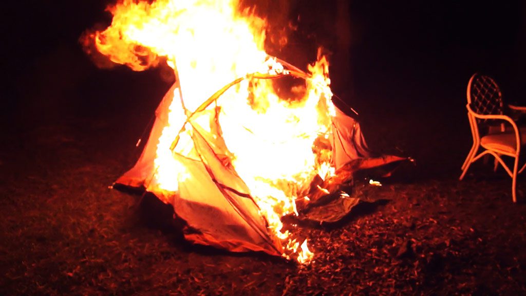 tent in brand op grasveld