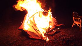 tent in brand op grasveld